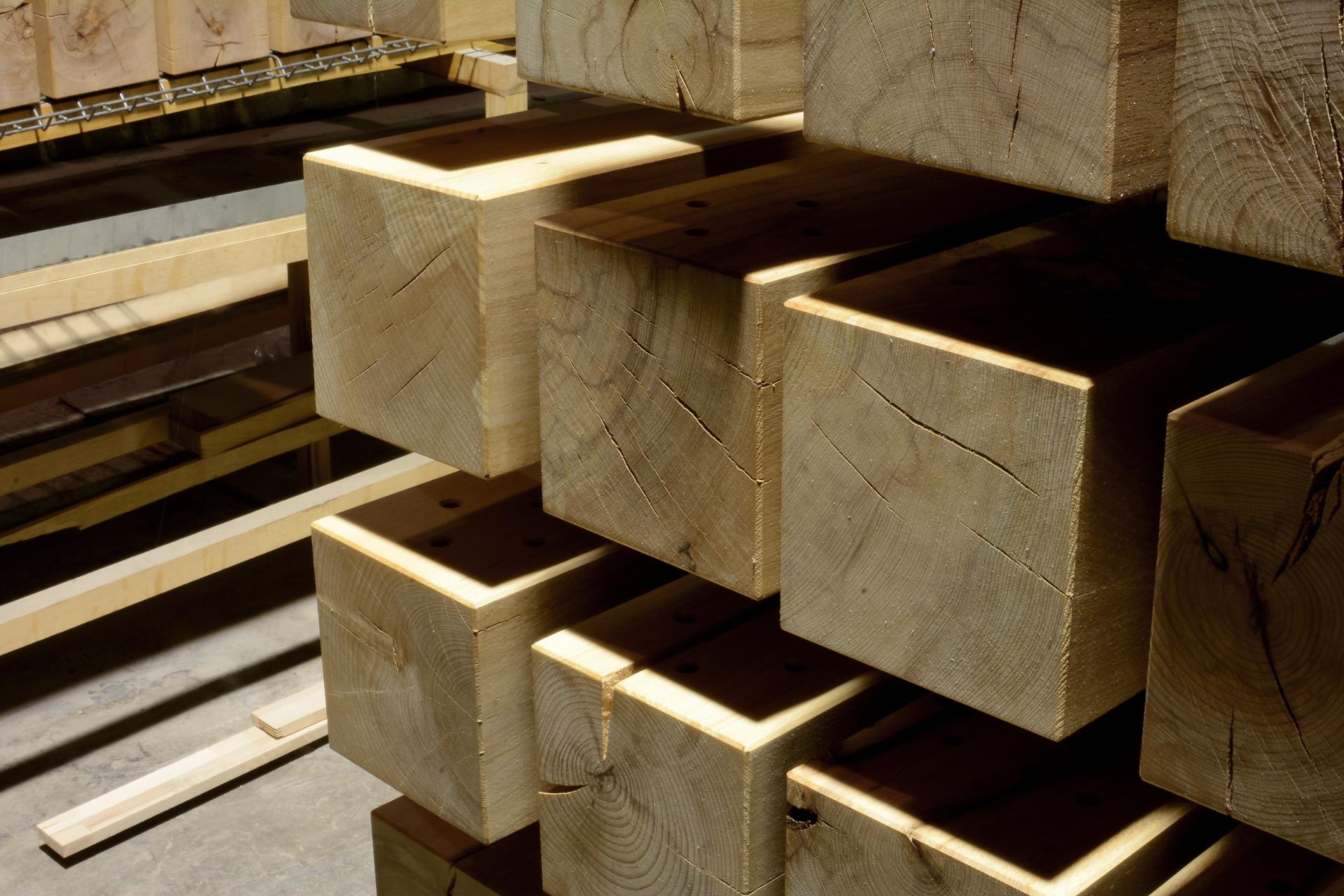 Stacked wooden blocks in a workshop, showcasing CRAFTWAND's commitment to sustainable wood sourcing and craftsmanship.