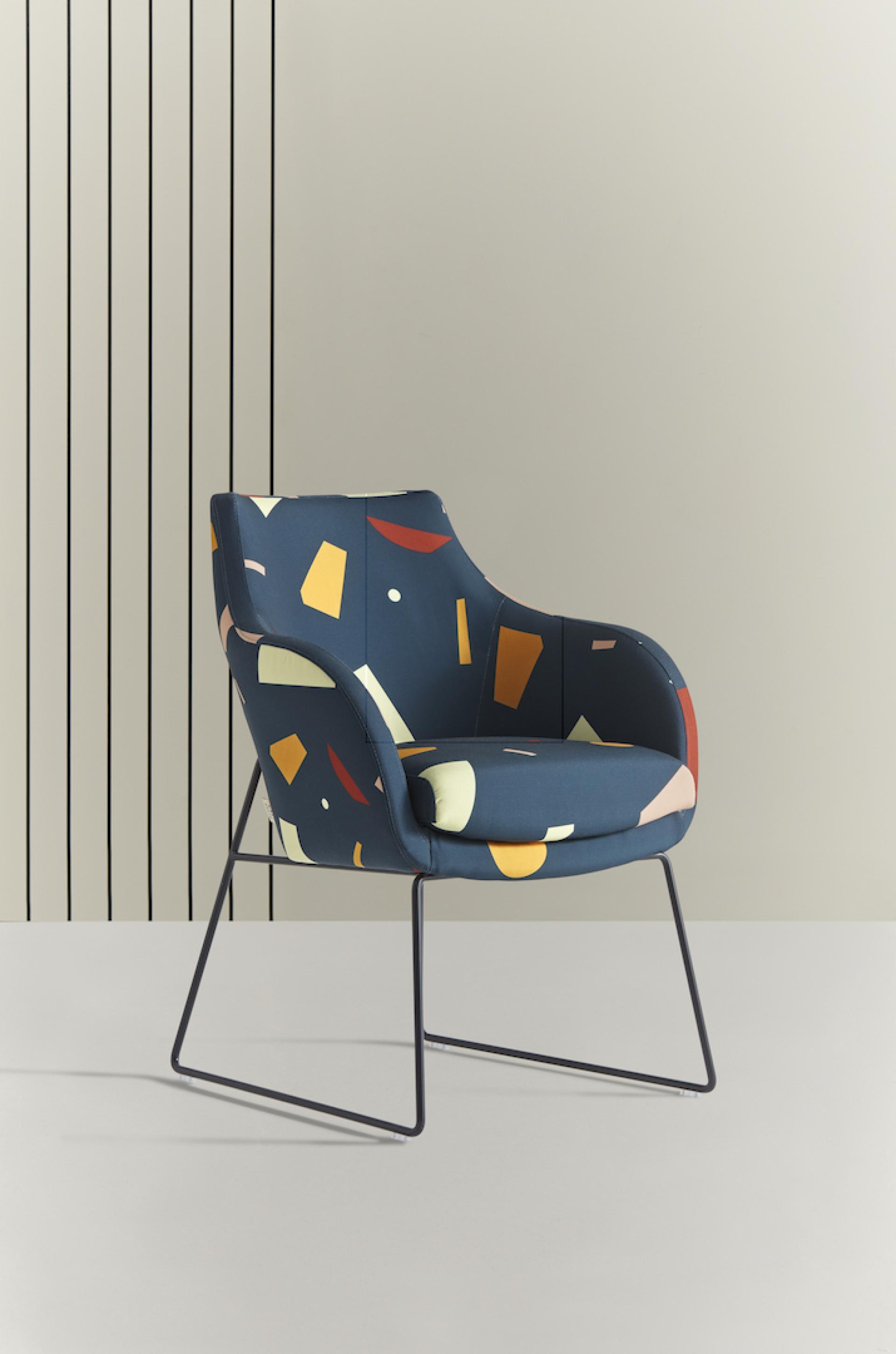 Colorful geometric-patterned chair by Tom Pigeon against a minimalist background, showcasing British design and creativity.