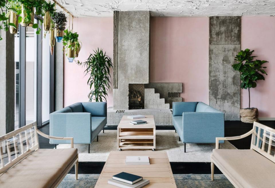 Stylish mid-century hotel lobby in Austin featuring pale pink walls, modern furniture, and lush greenery.