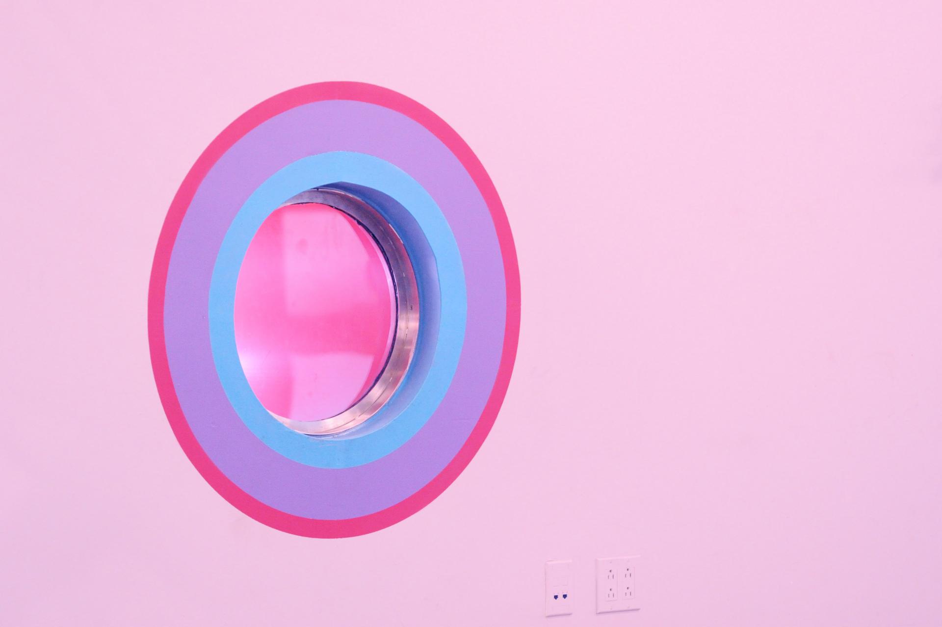 Colorful circular window design in ColorLab's pink art-making space for children in Brooklyn.