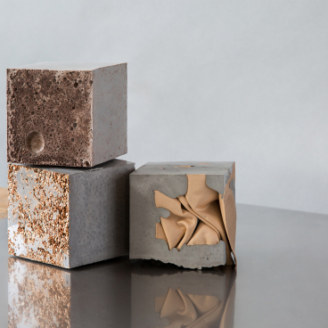 Three textured concrete cubes, showcasing unique finishes, representing innovative design at the Surface Design Show 2019.