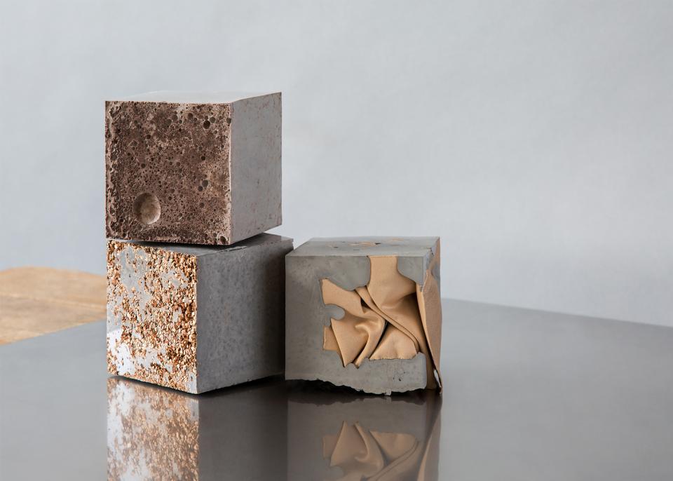 Three textured concrete cubes, showcasing unique finishes, representing innovative design at the Surface Design Show 2019.