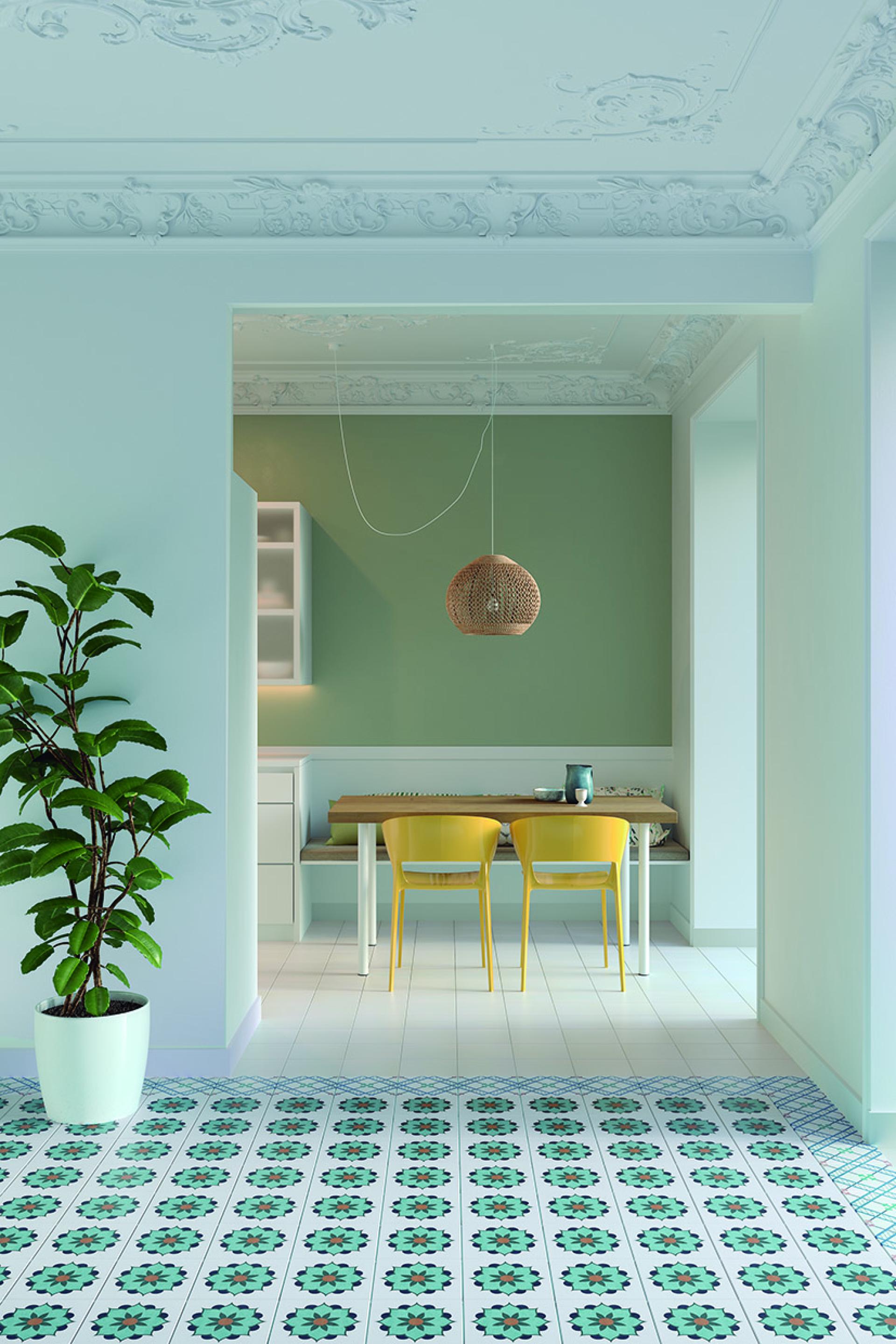 Bright, modern kitchen featuring patterned terrazzo tile flooring, wooden dining table, and vibrant yellow chairs against green walls.