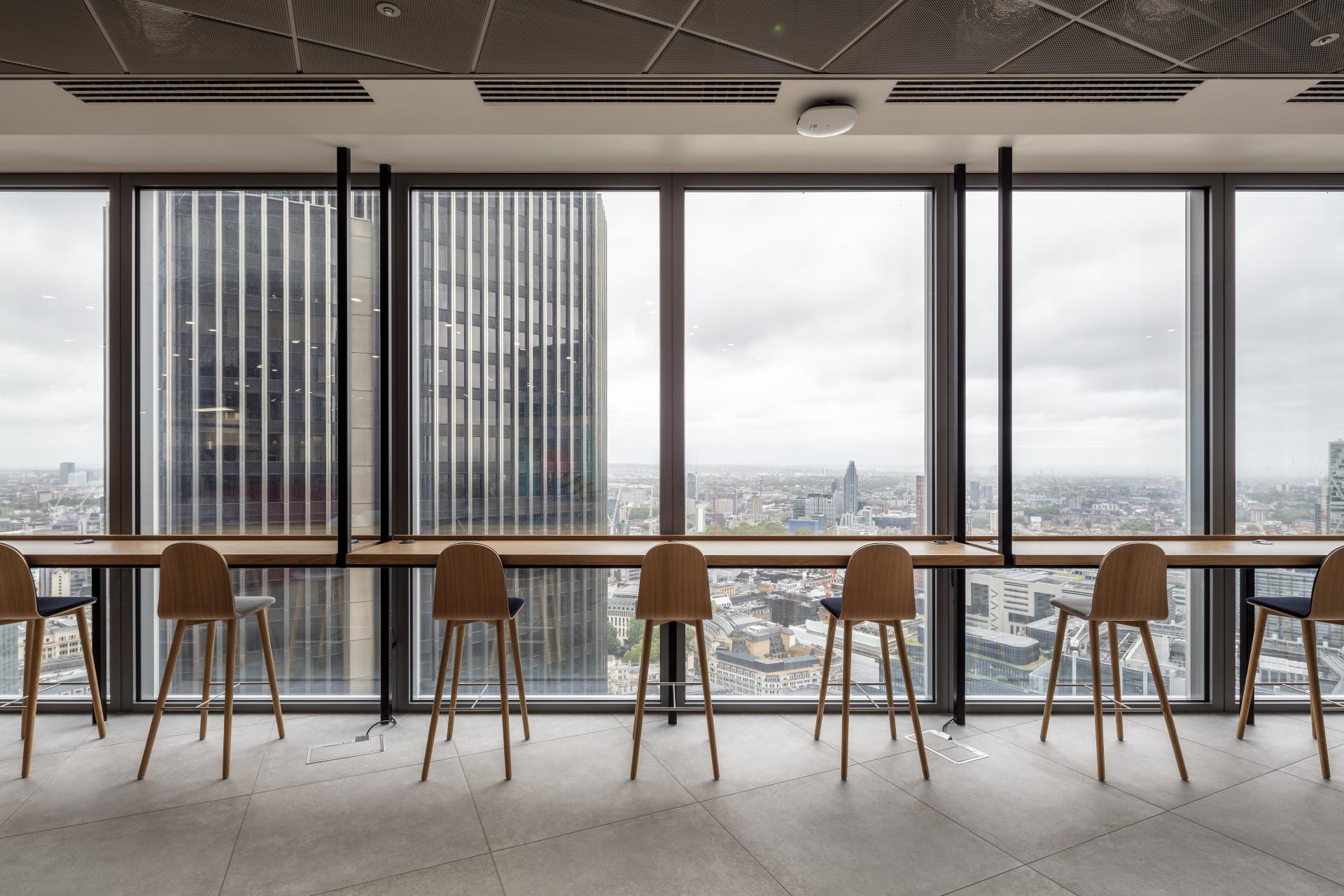Modern office interior featuring high stools and a panoramic view of London from 22 Bishopsgate.