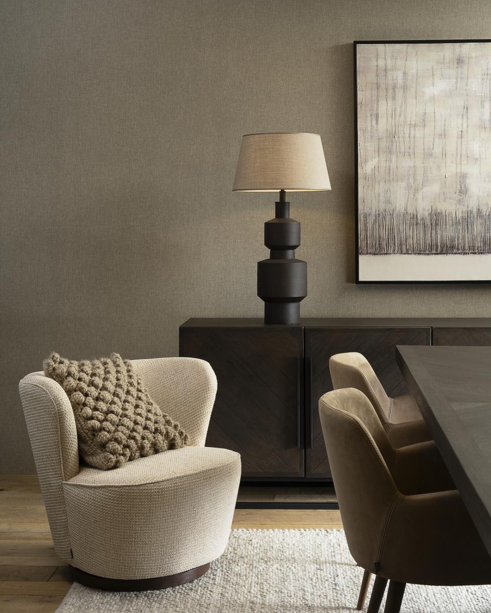 Cozy interior featuring a stylish chair, textured wall, modern lamp, and elegant dining table from Arte's 2025 collection.