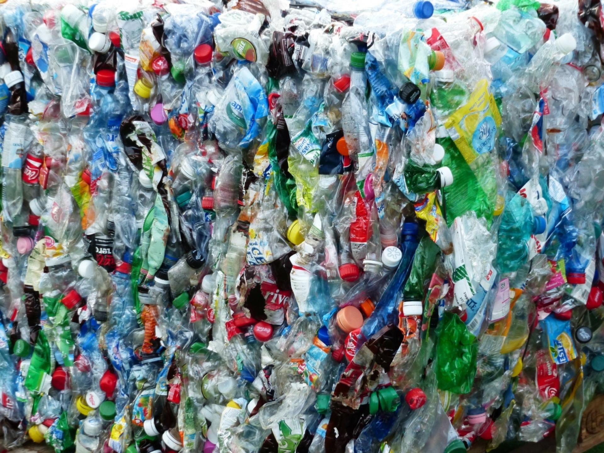 Colorful plastic bottles and caps stacked together, highlighting the issue of waste management and recycling in 2021.