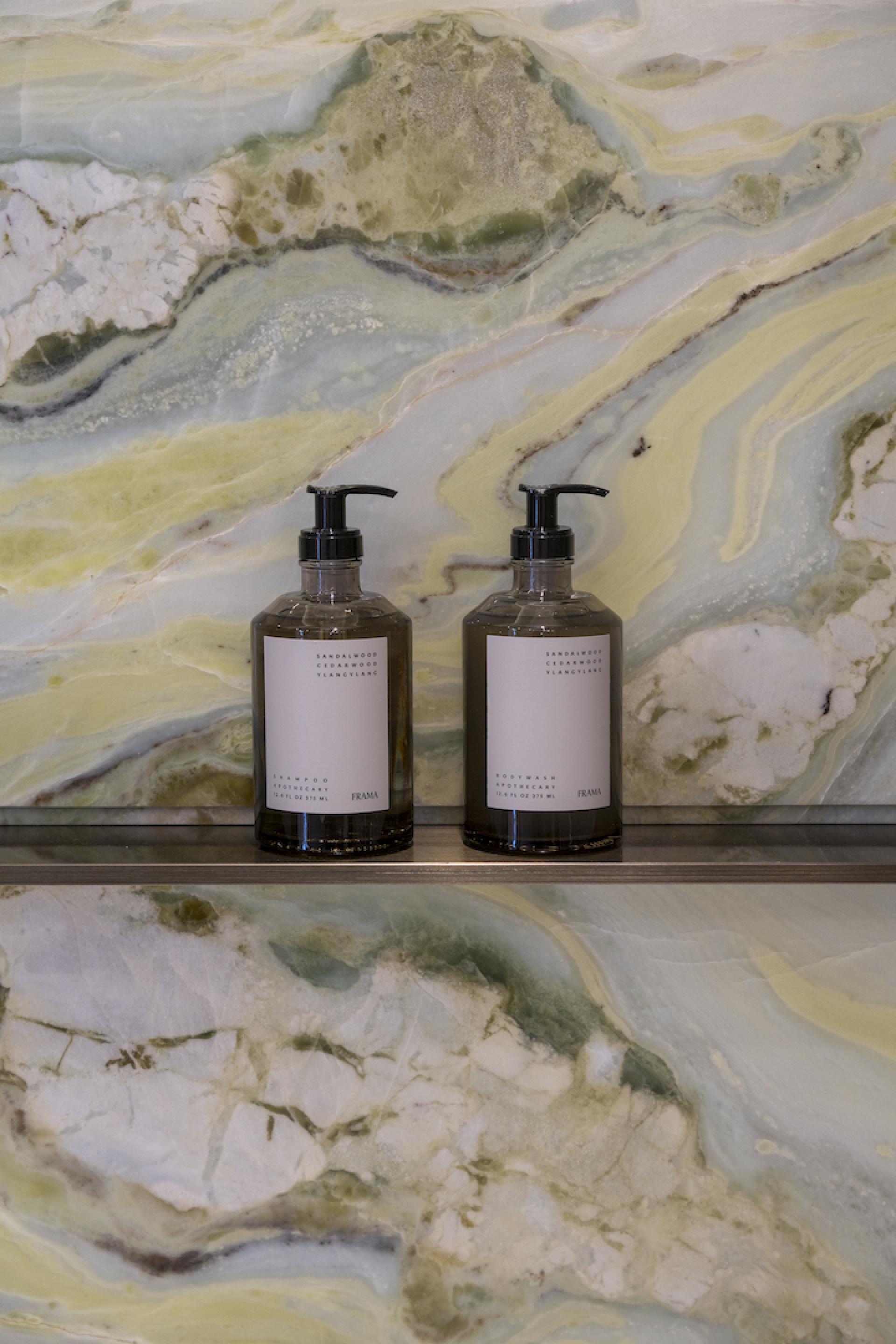 Elegant bathroom setup featuring Frama hand wash bottles against a stunning onyx backdrop, showcasing Chinese five-elements philosophy in design.