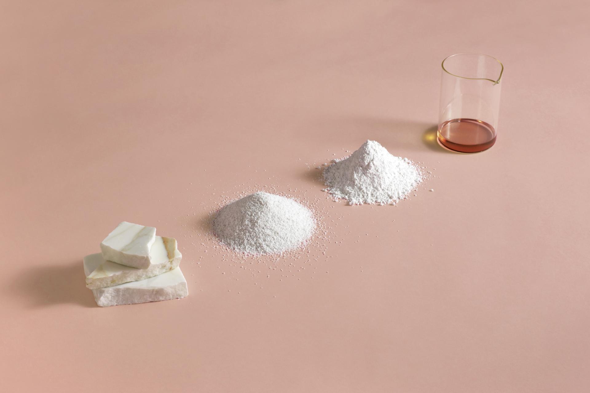 Natural materials crafted into various textures, featuring solid pieces, powders, and a liquid in a glass container.