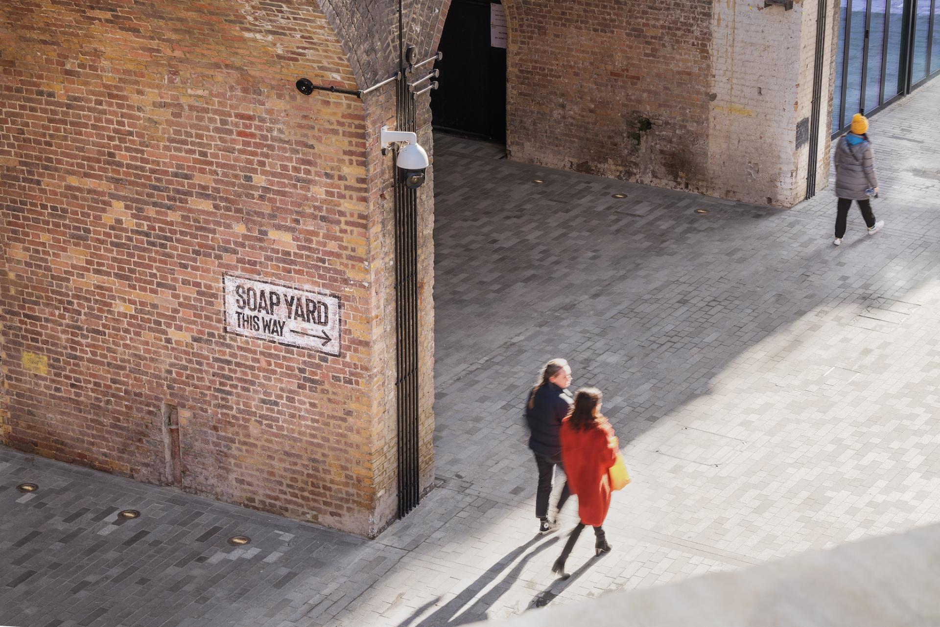 Visitors stroll through Borough Yards, with a directional sign indicating the way to Soap Yard.