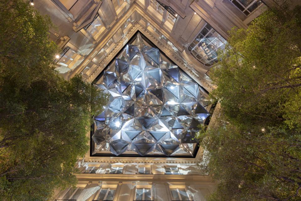 Architectural view of the Apple Champs-Élysées store with a stunning glass ceiling surrounded by trees in Paris.