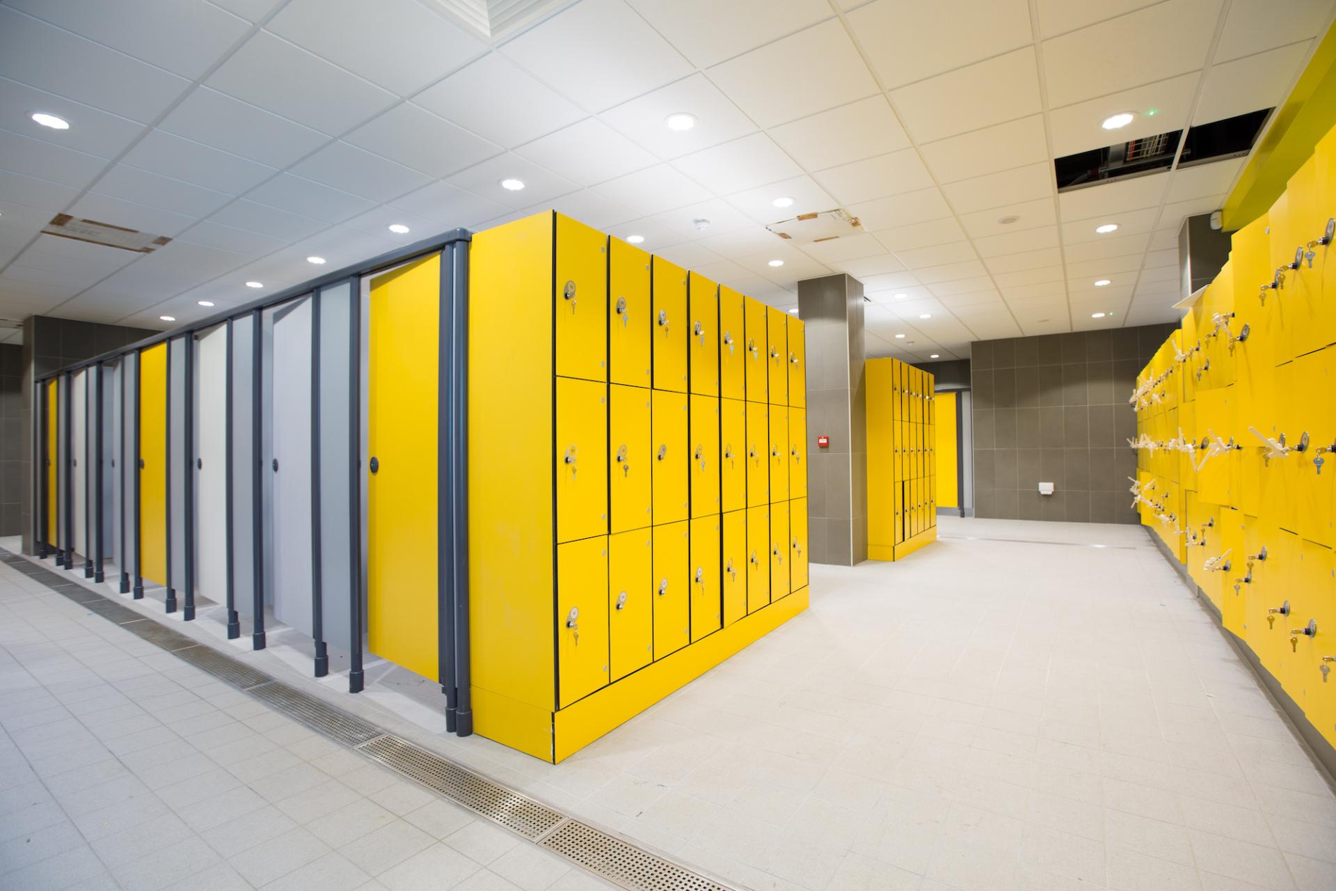 Brightly colored yellow lockers line a modern changing room, showcasing innovative design in the Material Source Studio.