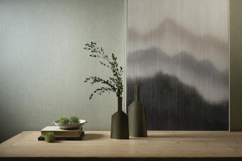 Stylish tabletop arrangement featuring ceramic vases and greenery against a textured wallcovering, showcasing Arte's 2025 collection.