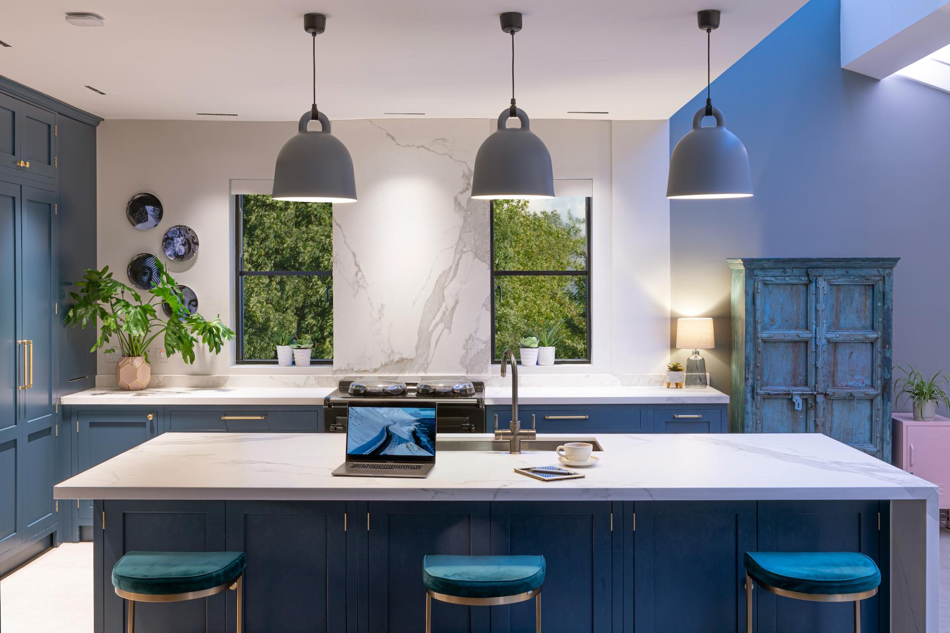 Modern kitchen design featuring sleek cabinetry, elegant lighting, and a marble countertop, highlighting the importance of effective lighting in interiors.