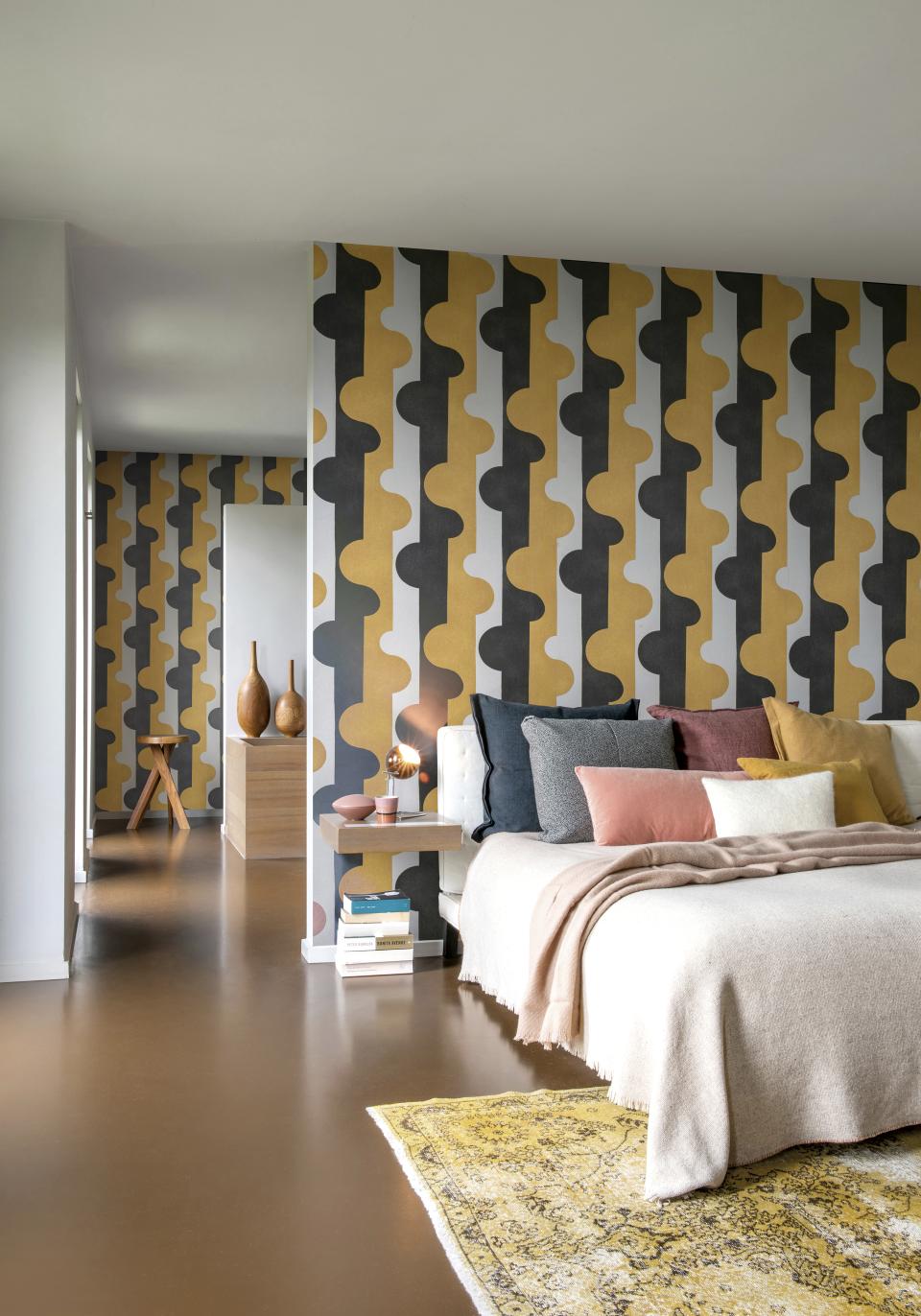 Stylish bedroom featuring Omexo's geometric wallcovering in earthy tones, with a cozy bed and decorative pillows.