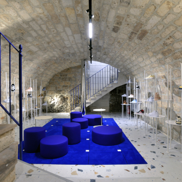 Futuristic concept store interior featuring electric blue decor and stylish sneaker displays in a unique Angoulême setting.