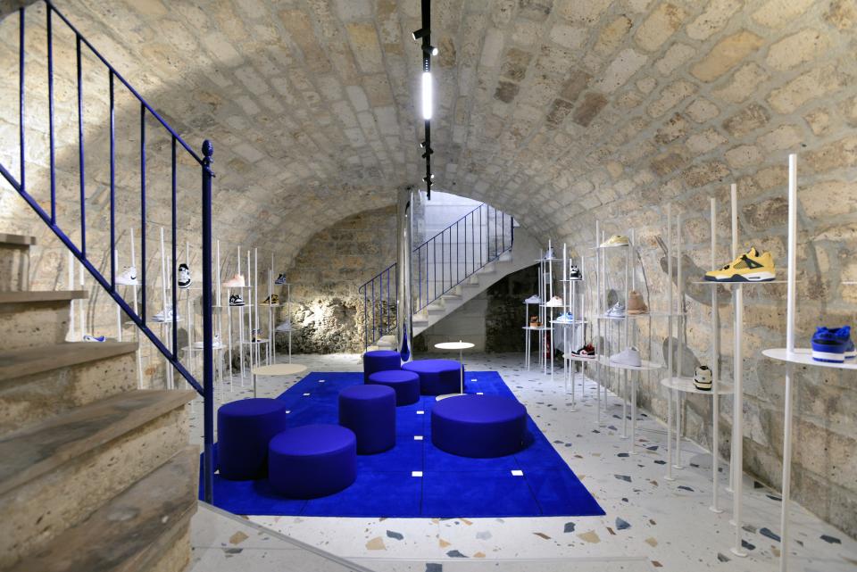 Futuristic concept store interior featuring electric blue decor and stylish sneaker displays in a unique Angoulême setting.
