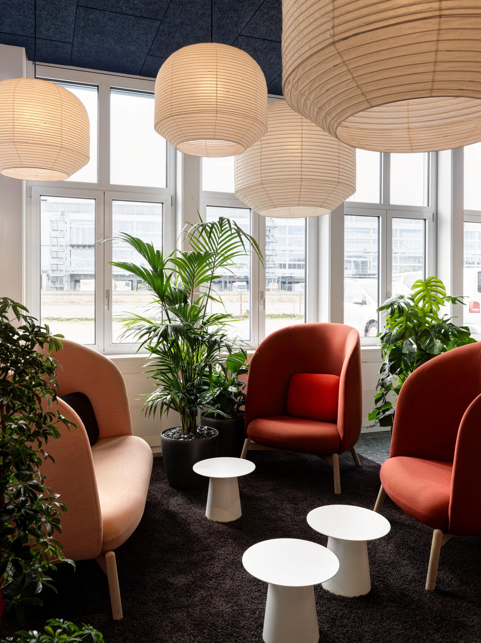 Modern lounge area designed by Studio Gessaga, featuring stylish seating, plants, and ambient lighting, ideal for collaborative workspaces.