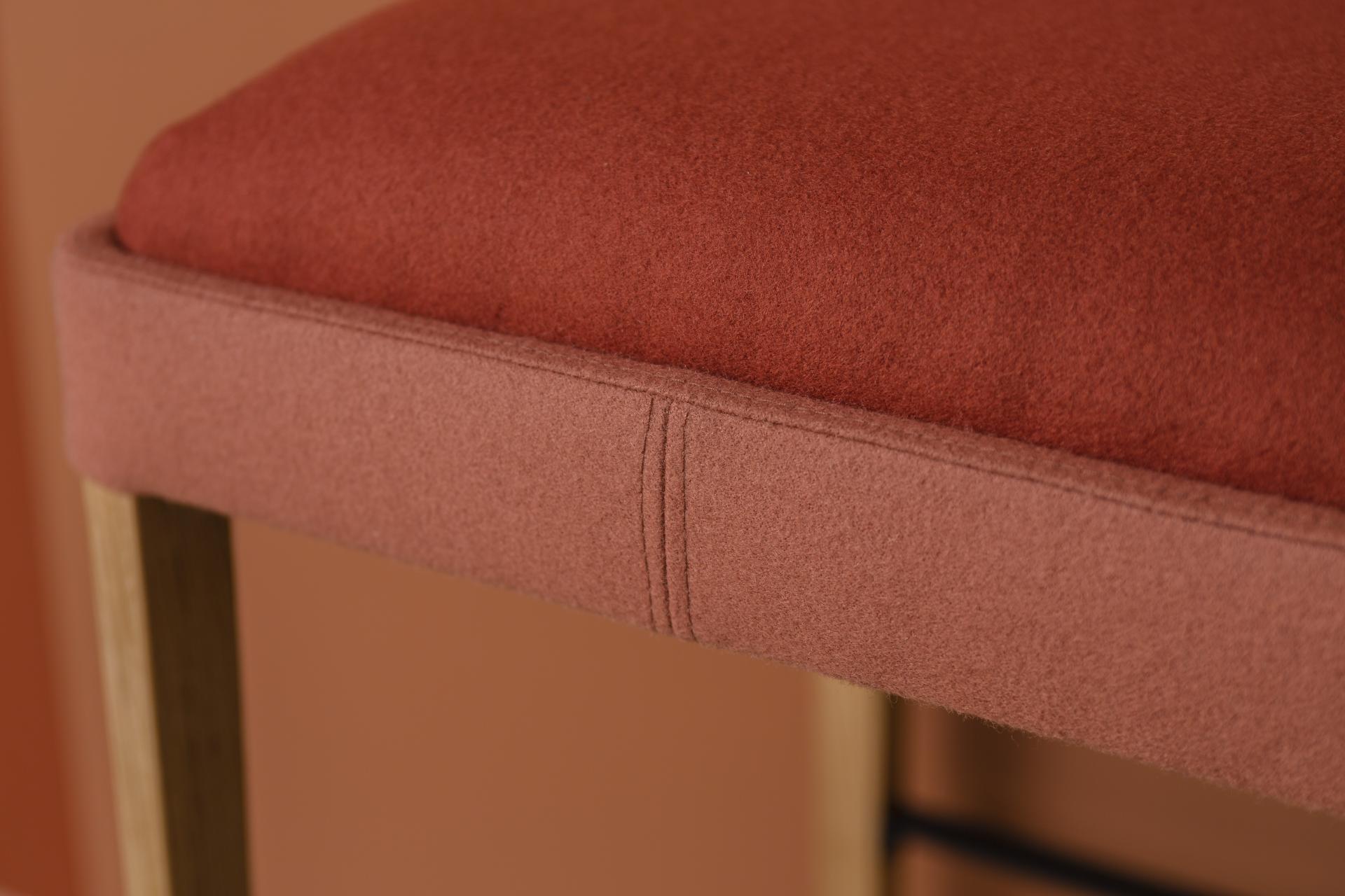 Stylish seating from the Kyoto collection, featuring a soft, terracotta upholstered cushion and wooden legs.