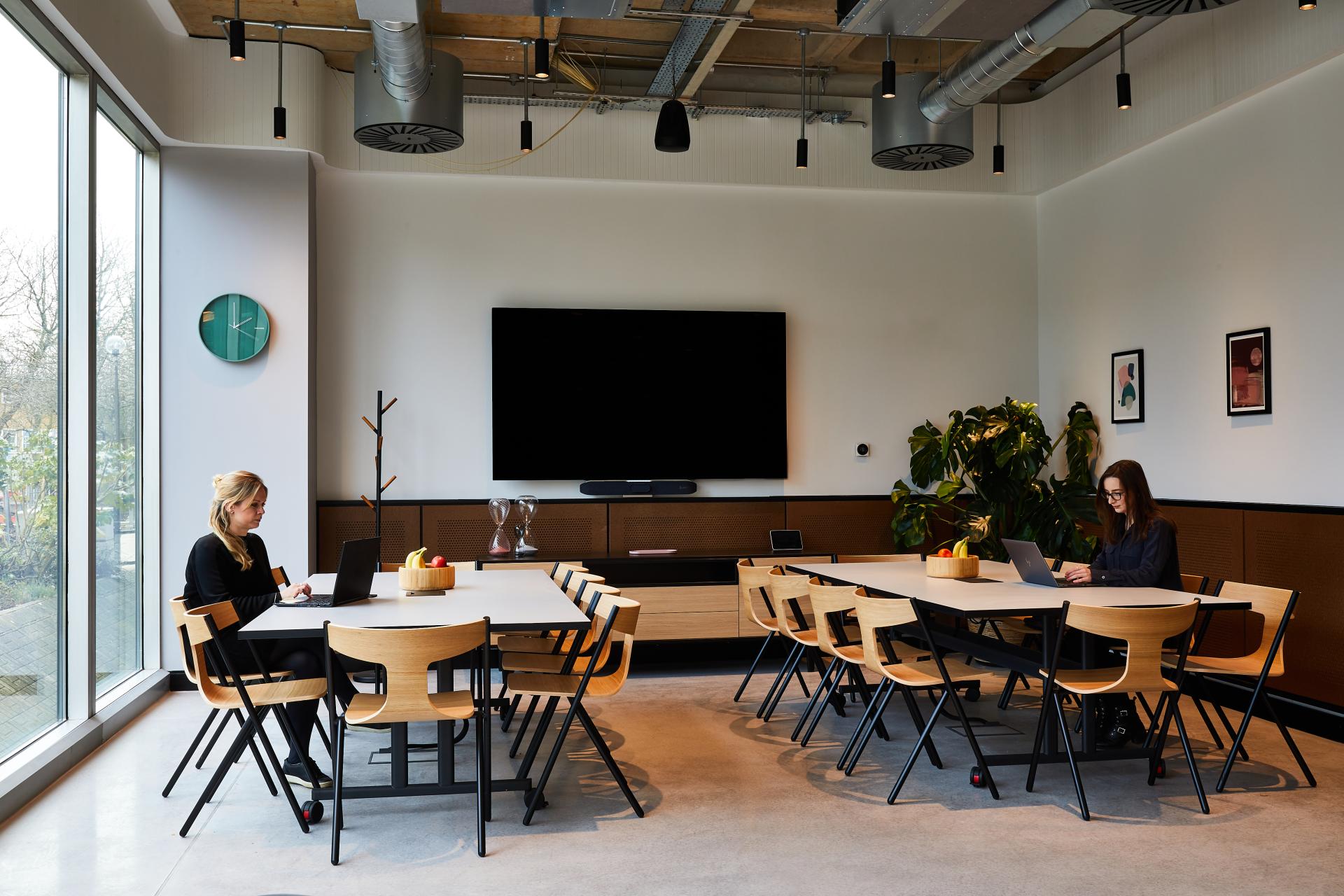 Modern conference room designed by SpaceInvader, featuring sleek furniture and large windows, enhancing collaboration and productivity.