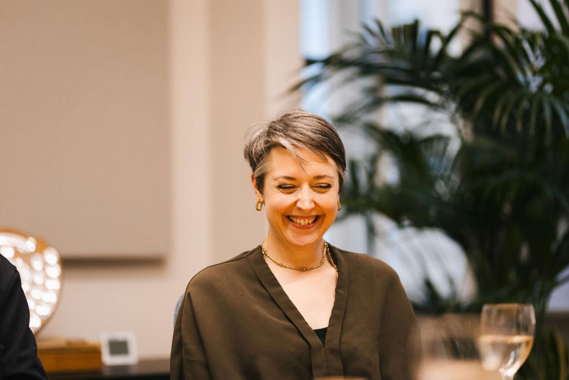 Smiling woman engaged in conversation during a seminar on Glasgow's property market trends and outlook.