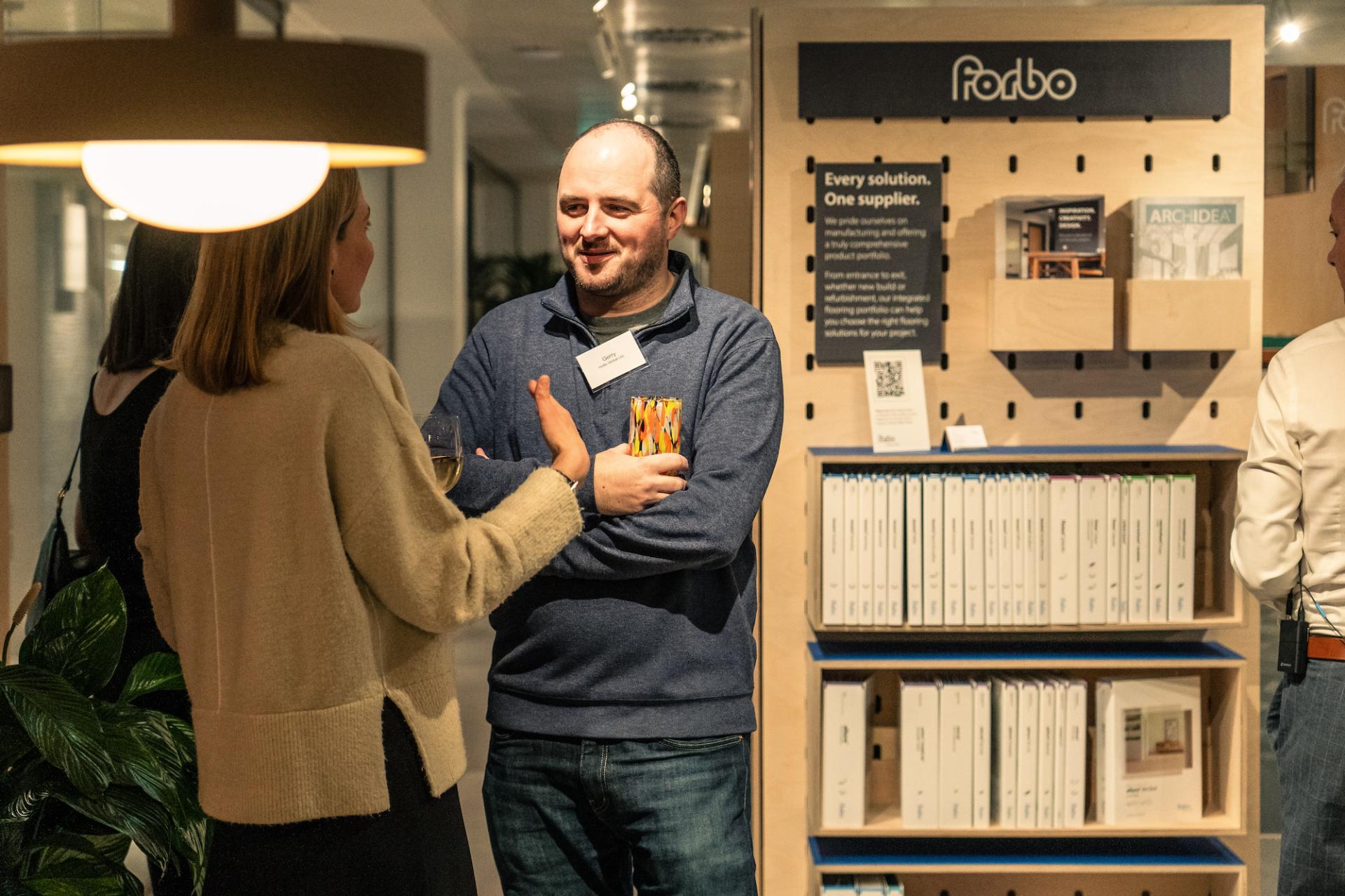 Participants engage in conversation at a sustainability event, surrounded by informative materials and displays about eco-friendly resources.