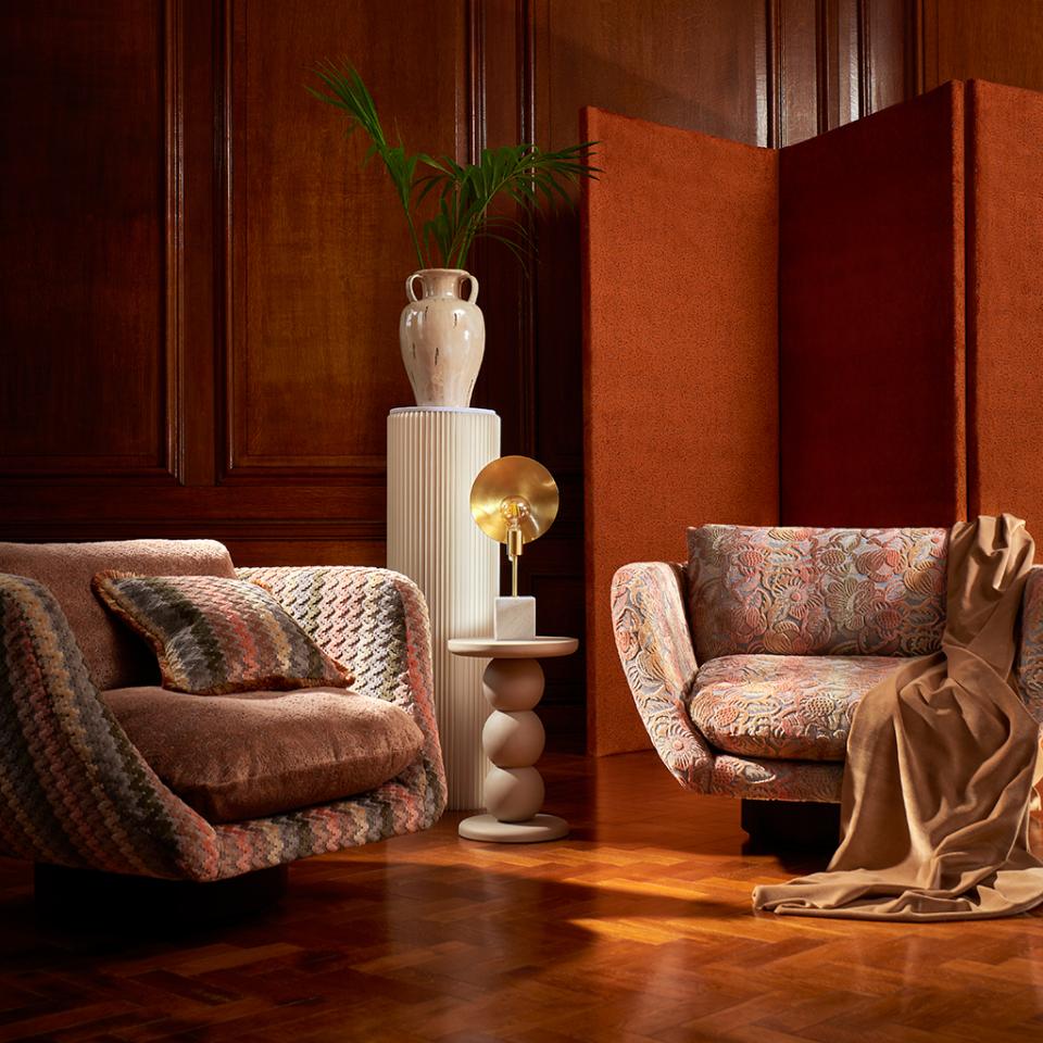 Stylish living room featuring Art Deco-inspired furniture with bold floral patterns, warm colors, and decorative accents.