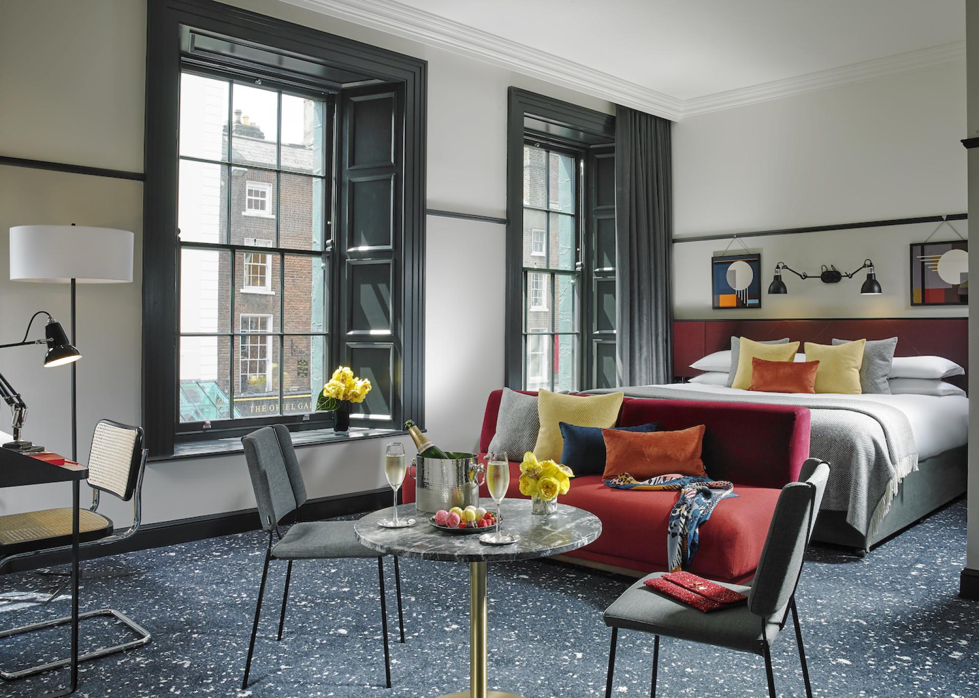 Stylish hotel room featuring contemporary decor, a seating area, and large windows with city views at The Mont Hotel.