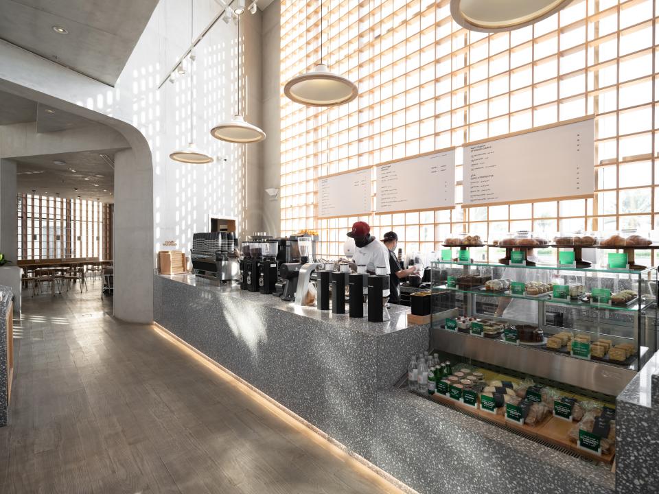 Stylish coffee shop interior featuring a Japandi design, with a modern counter and natural light illuminating the space.