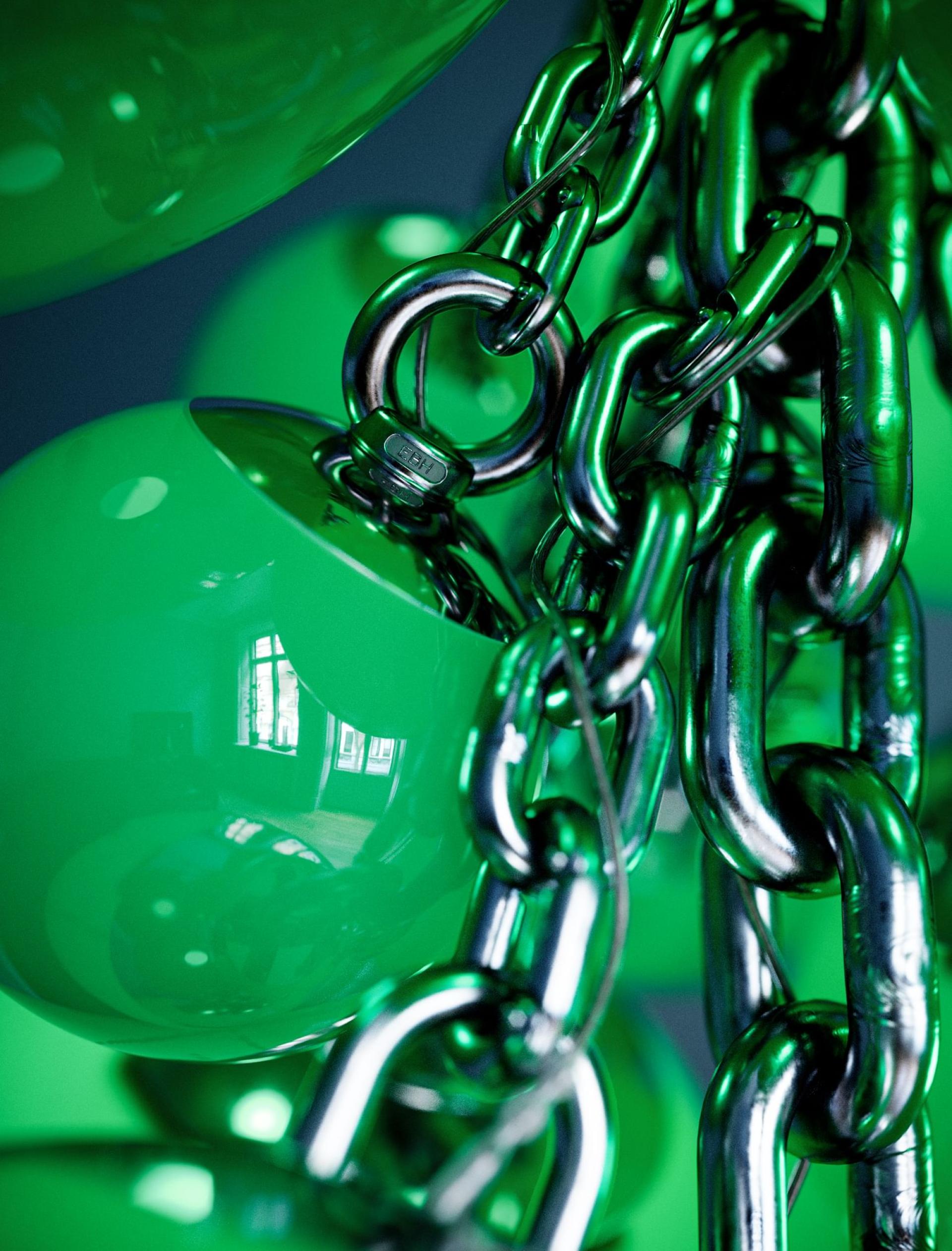 Close-up of the Kuulas chandelier showcasing glossy green spheres and metallic chains, highlighting its sculptural design and craftsmanship.