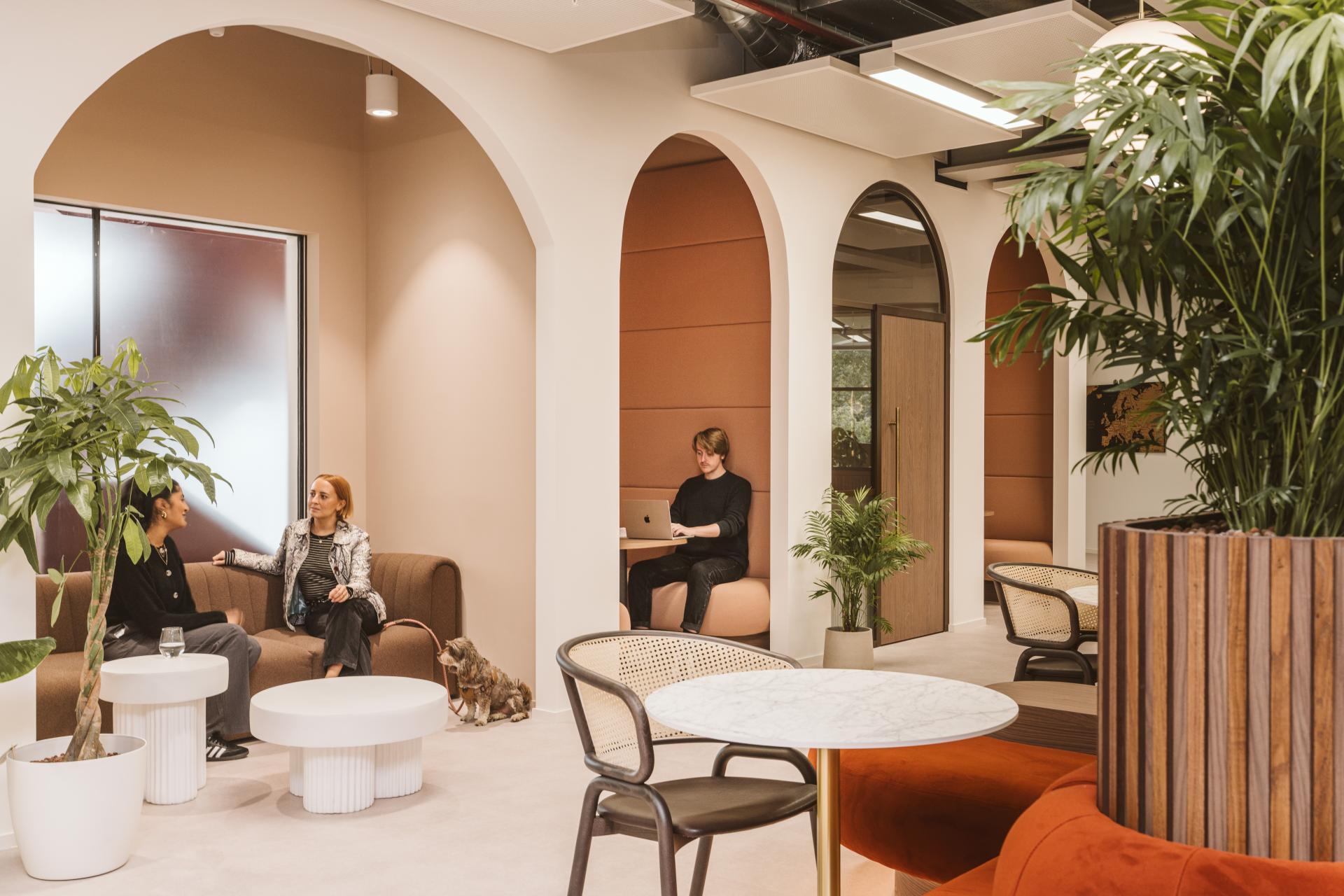 Modern workspace featuring employees and a dog, designed for comfort and collaboration at Butternut Box.