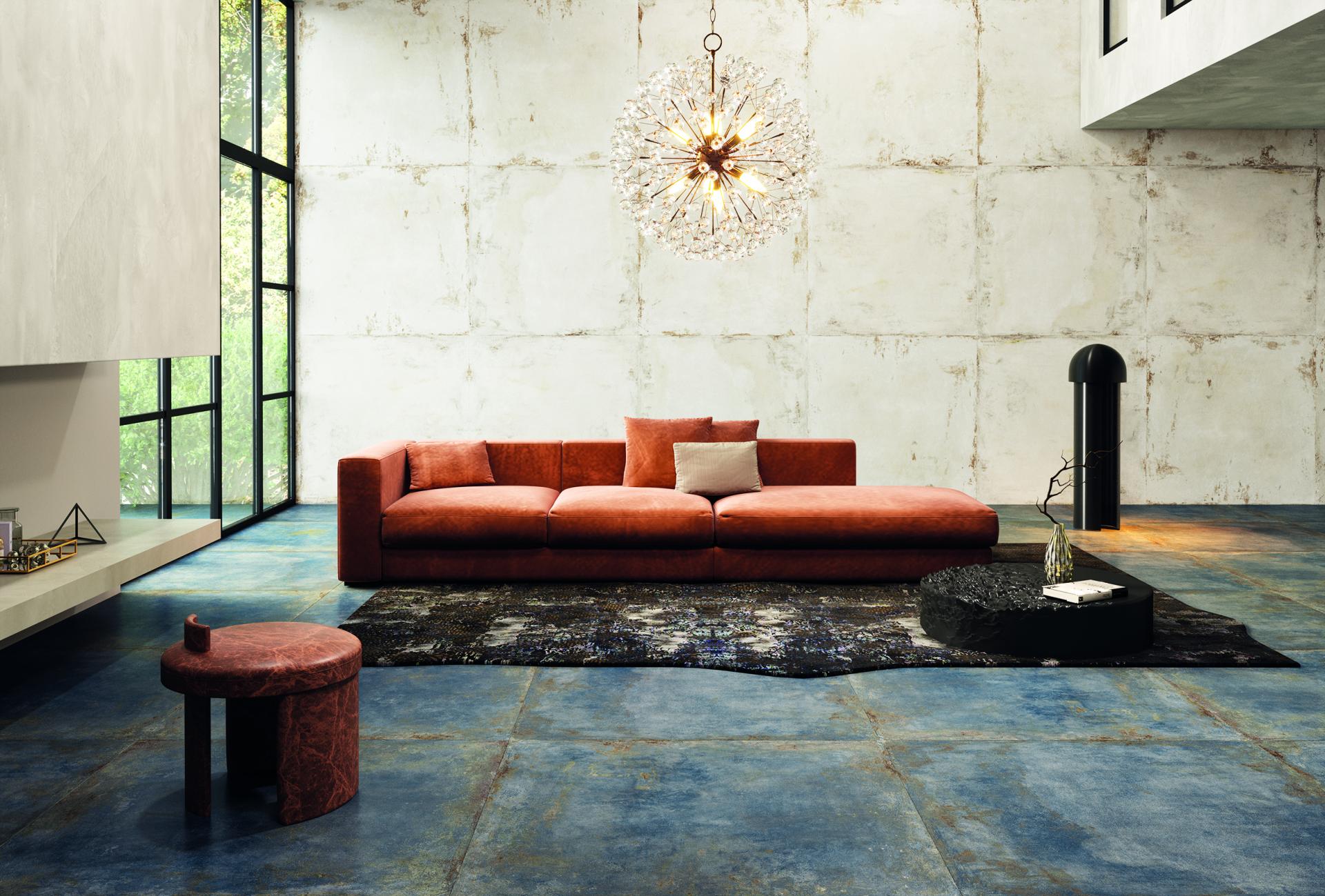 Modern living room featuring an orange sofa, textured walls, artistic lighting, and stylish ceramic flooring from Cevisama 2023 trends.