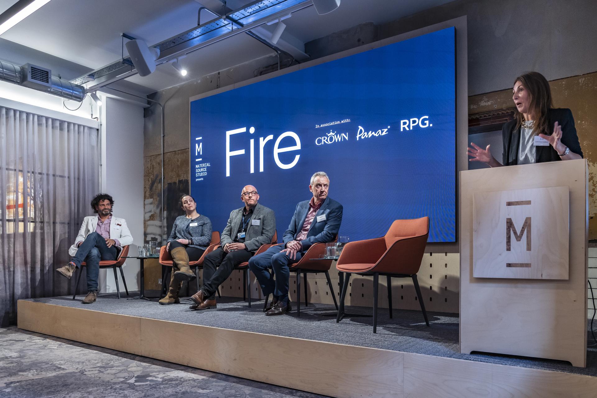 Panel discussion at Material Source Studio event titled 'Fire', featuring speakers and an engaging presentation backdrop.