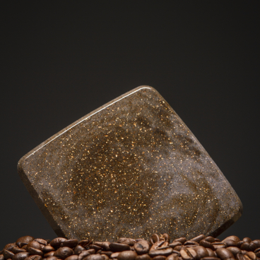 A lightweight granite-like material resembling That’s Caffeine, displayed atop roasted coffee beans.