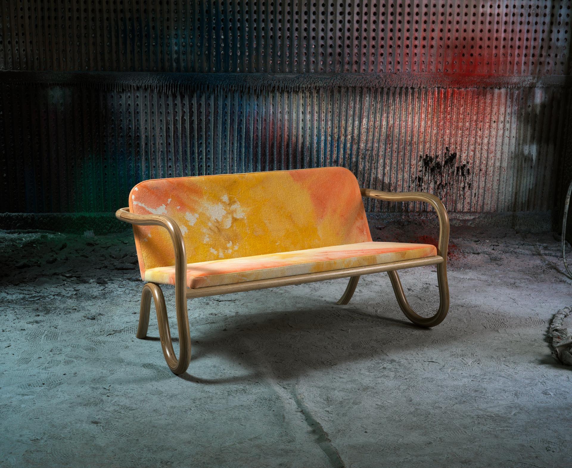 Bespoke Kolho sofa by Matthew Day Jackson, showcasing vibrant orange upholstery and unique design against an industrial backdrop.