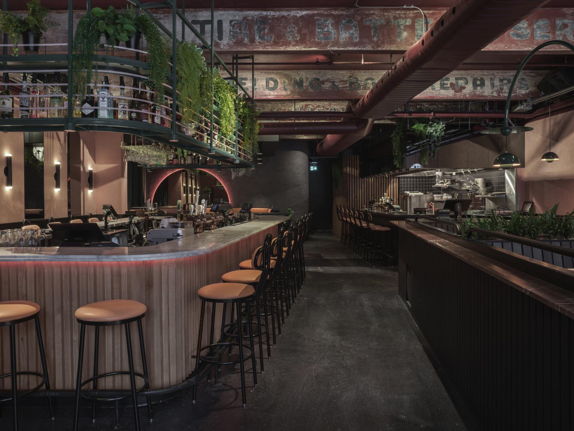 Tropical-themed restaurant interior in Montreal featuring a modern bar, stylish seating, and lush greenery.