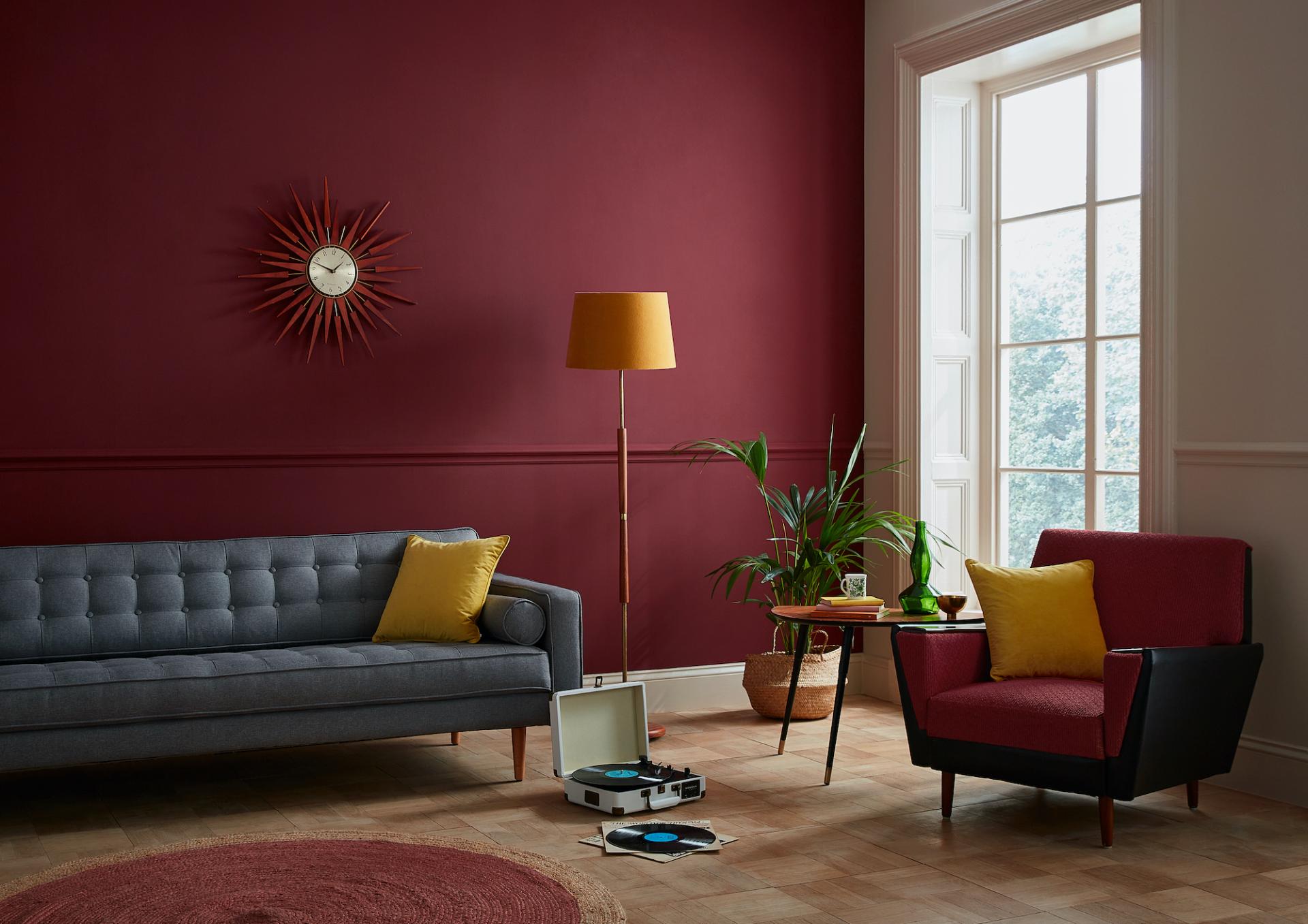 Stylish living room featuring a rich burgundy wall, modern furniture, and a curated color palette for 2021.