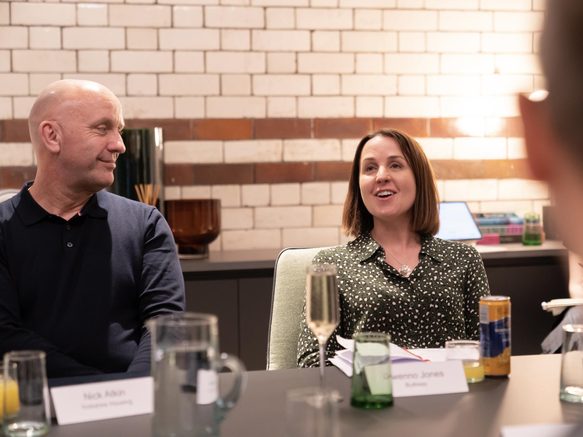 Participants engaged in a technology seminar discussion, focused on a technologically advanced workplace setting.