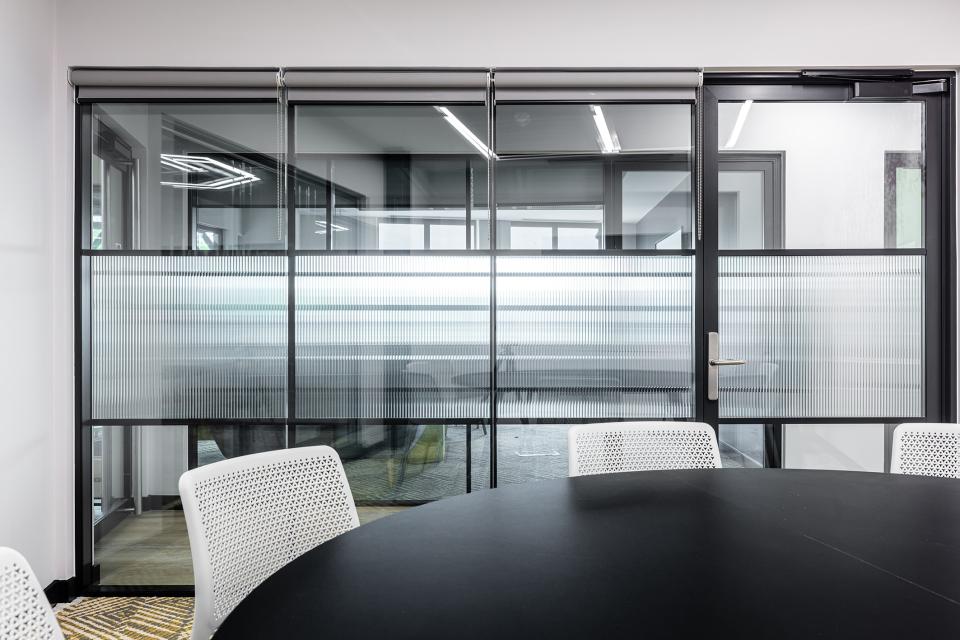 Modern glass meeting room with sliding doors, providing a collaborative workspace at The Bee House, Milton Park.