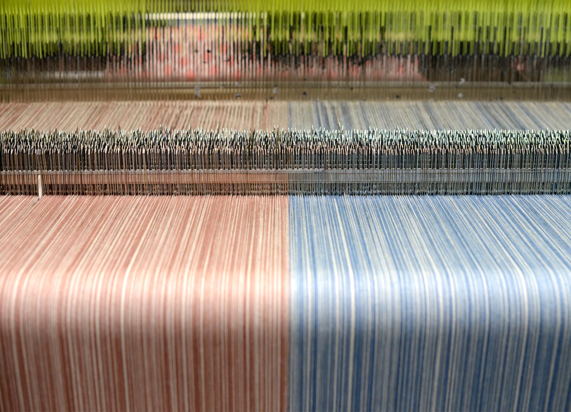 Colorful threads in a weaving loom at Yorkshire Sculpture Park, illustrating the transformation of British wool.