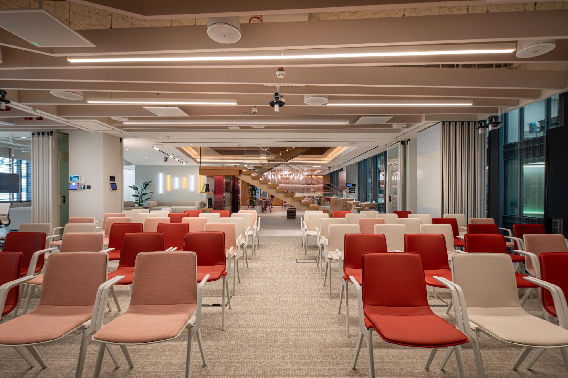Vibrant seating arrangement in a modern Dubai workplace, featuring red and white chairs, fostering creativity and collaboration.