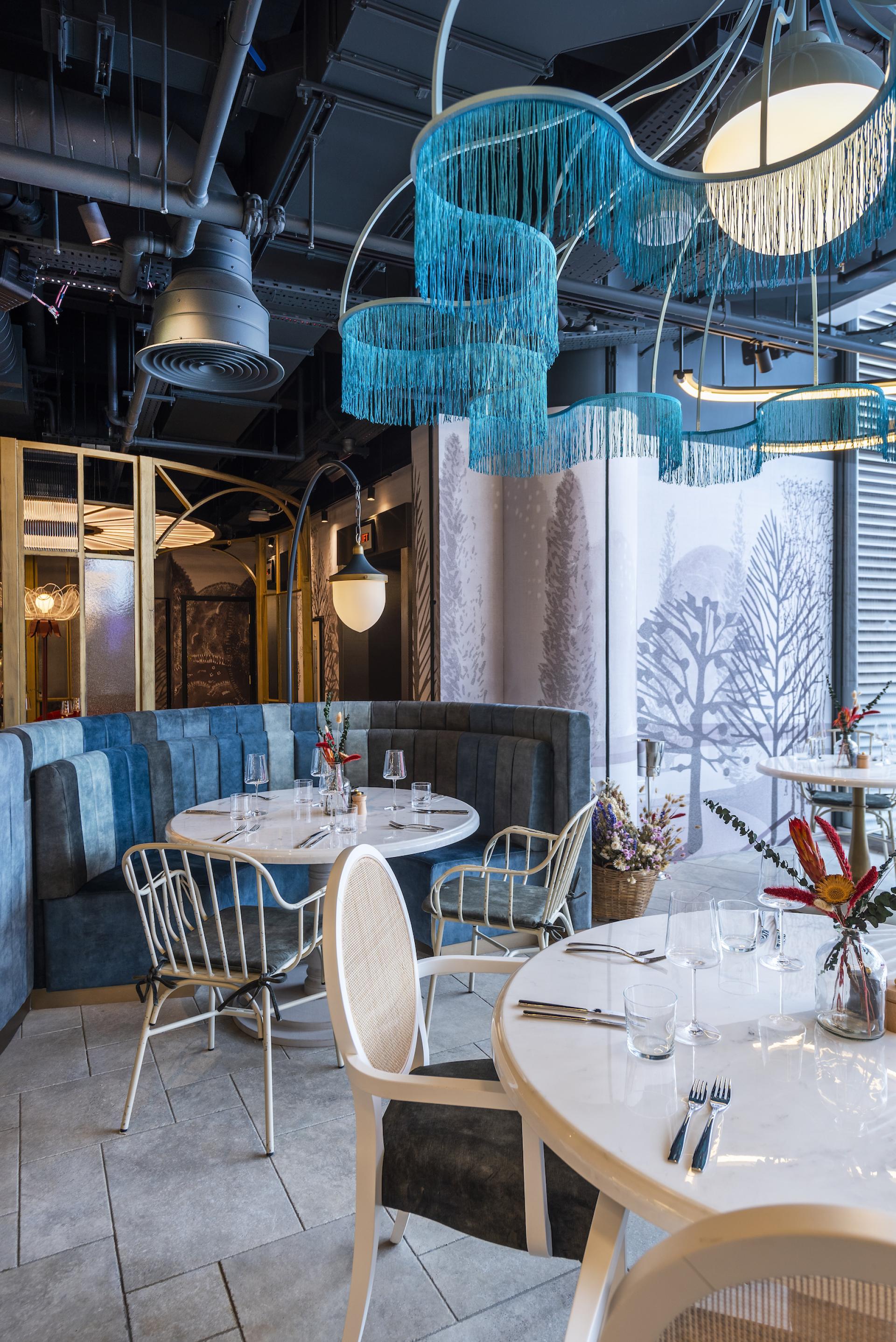 Stylish dining area with modern decor, featuring unique lighting and vibrant floral arrangements inspired by Wonderland.