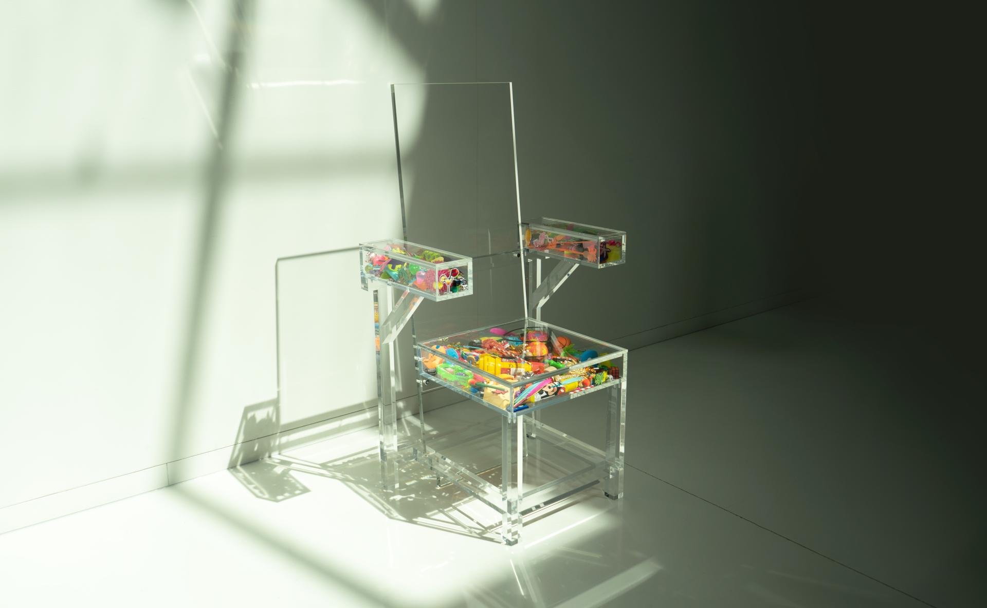 Transparent chair with colorful toys inside, showcasing innovative design and creativity in contemporary furniture.