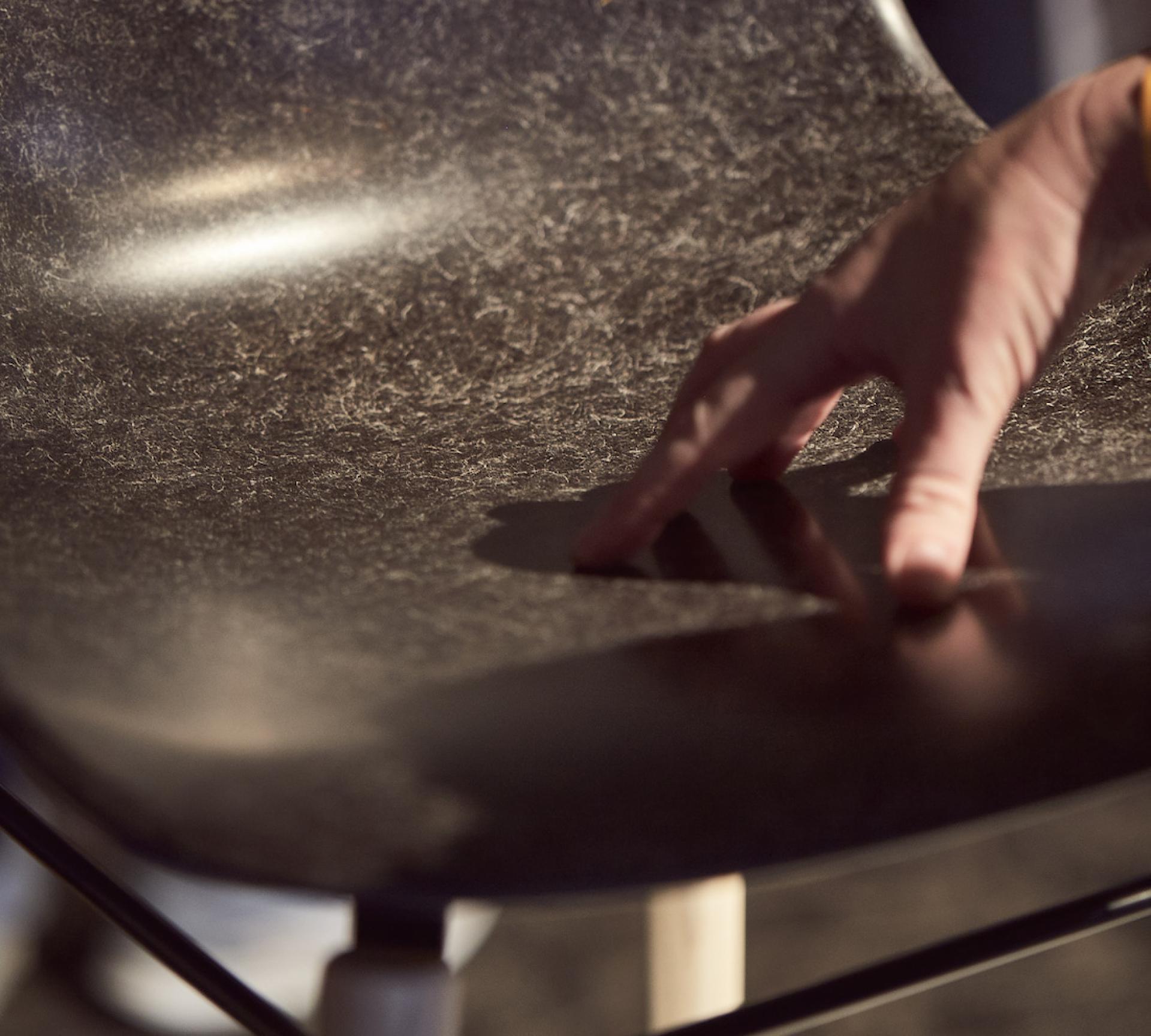 Sustainable chair design featuring innovative biomaterials, showcasing a hand interacting with the textured surface at LDF22.