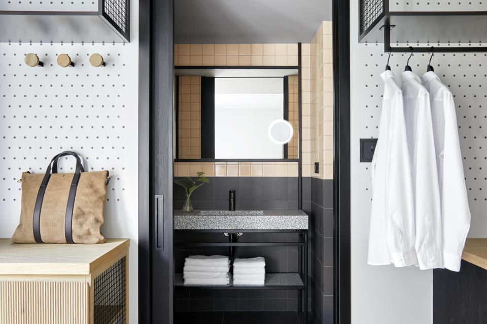 Stylish bathroom interior at PURO Kraków Kazimierz featuring modern tiles, a sleek vanity, and organized storage solutions.