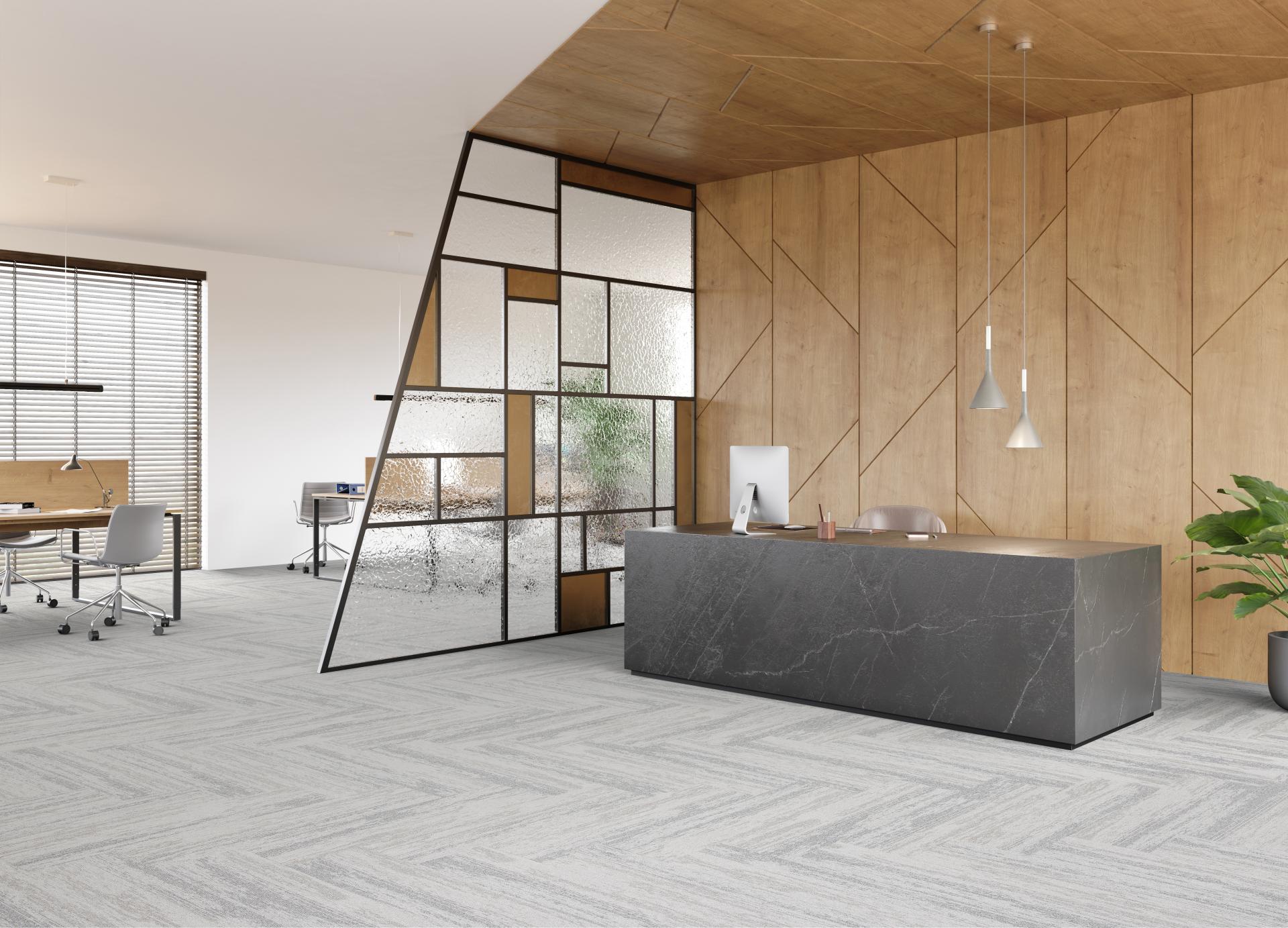 Modern office reception area featuring IVC's Rudiments carpet tiles, sleek furniture, and stylish glass partition.