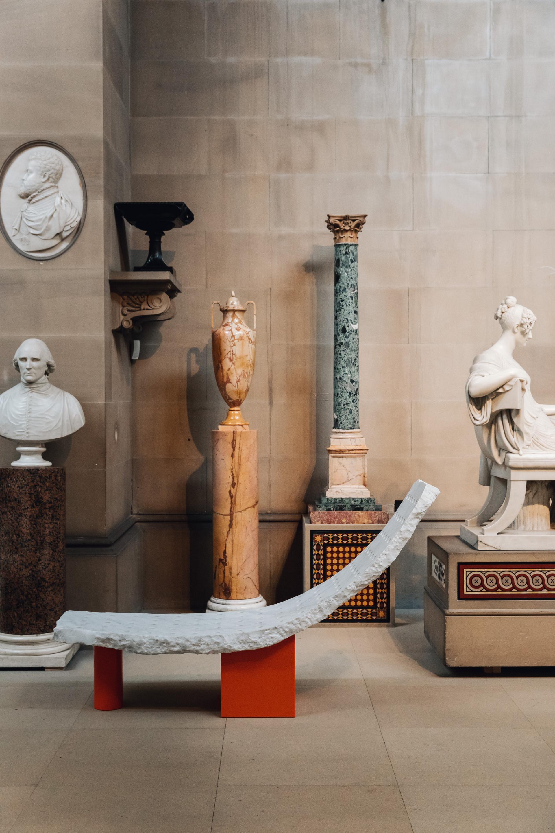 Contemporary sculpture alongside classical busts and ornate columns in Chatsworth House highlights its rich artistic heritage.