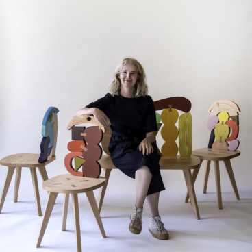 Contemporary furniture designer poses with colorful abstract chairs, showcasing SCP and Donna Wilson's innovative design collaboration.