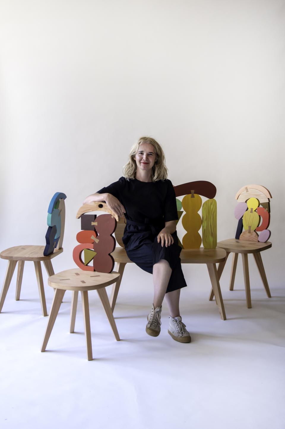 Contemporary furniture designer poses with colorful abstract chairs, showcasing SCP and Donna Wilson's innovative design collaboration.