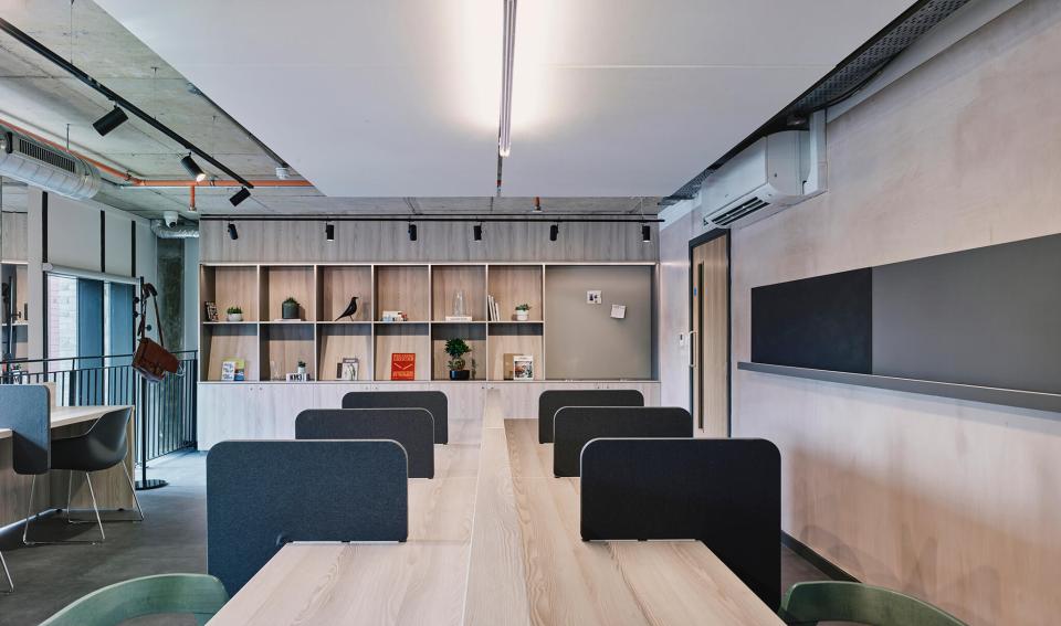 Modern study area at The Tannery in Leicester, featuring communal tables and stylish wooden shelving.