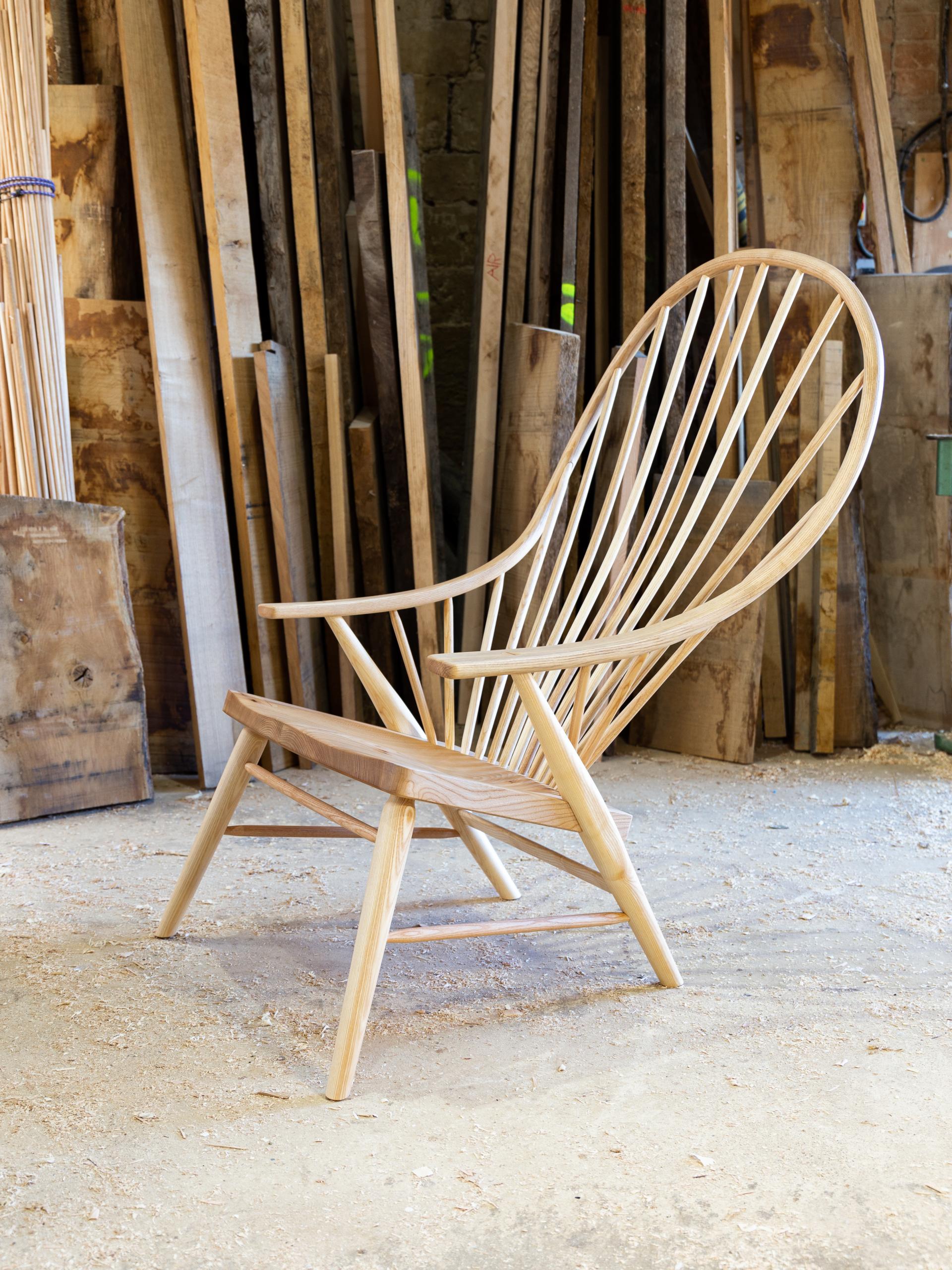 Sleek wooden chair showcased in a workshop, highlighting craftsmanship at the Future Icons Selects exhibition, London Craft Week 2023.